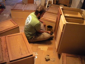 Staining the cabinets (in the same place as the door painting, such a versatile house.